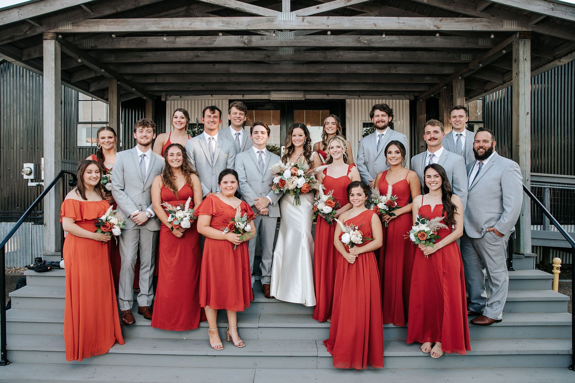 The bride and groom are posing for a picture with their wedding party.