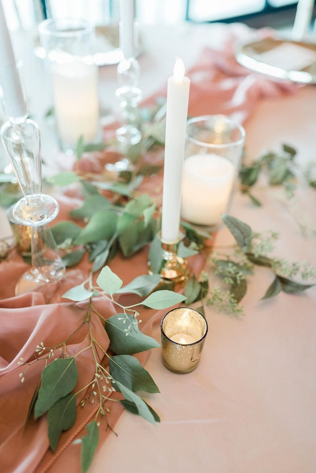 A table with candles and leaves on it.