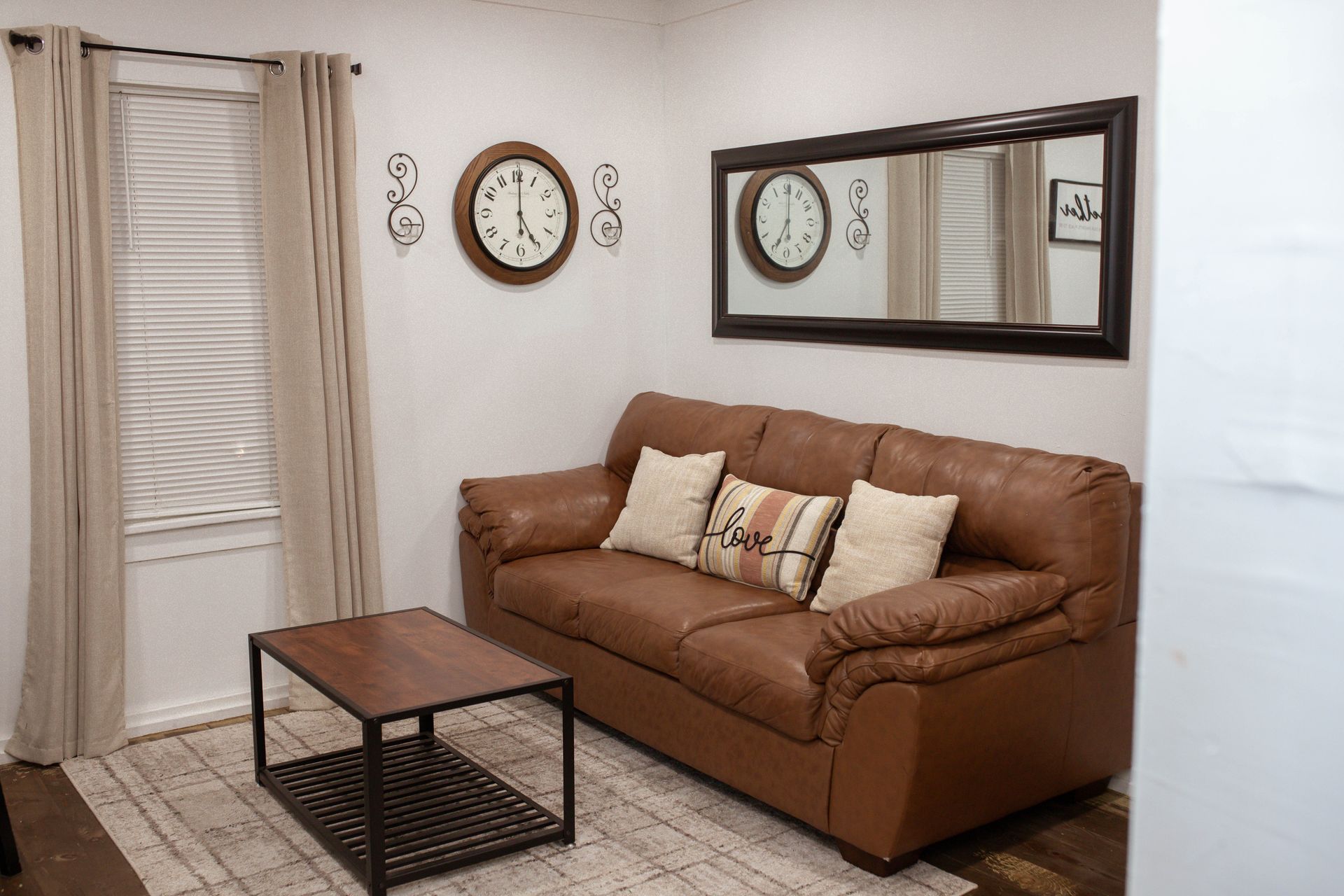 A room with a table , stools , a mirror and a mirror on the wall.