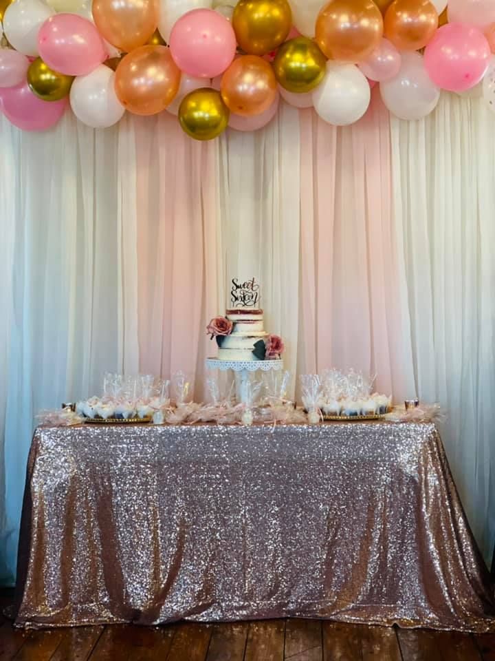 A table with a cake and balloons on it.