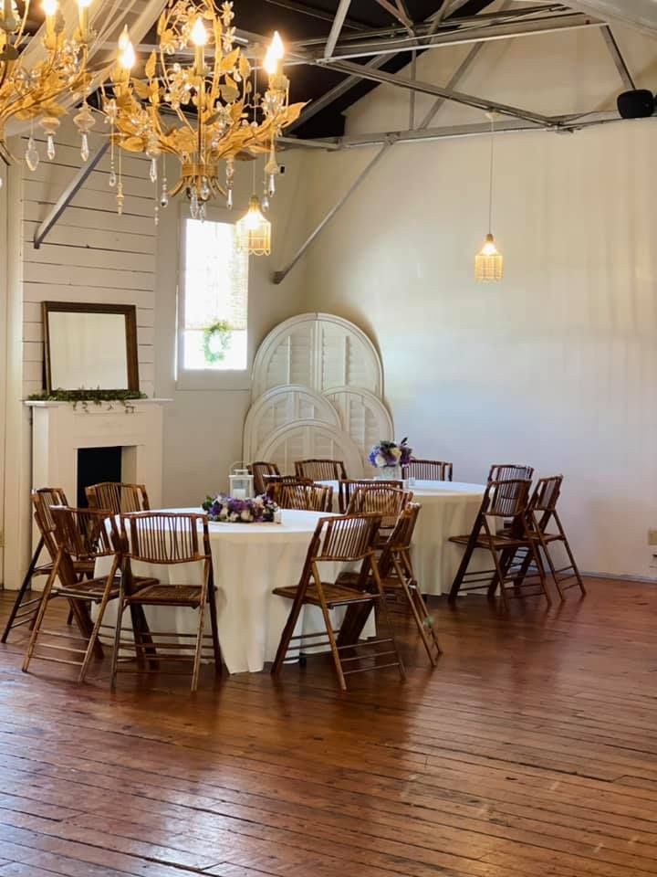 A room filled with tables and chairs and a chandelier.