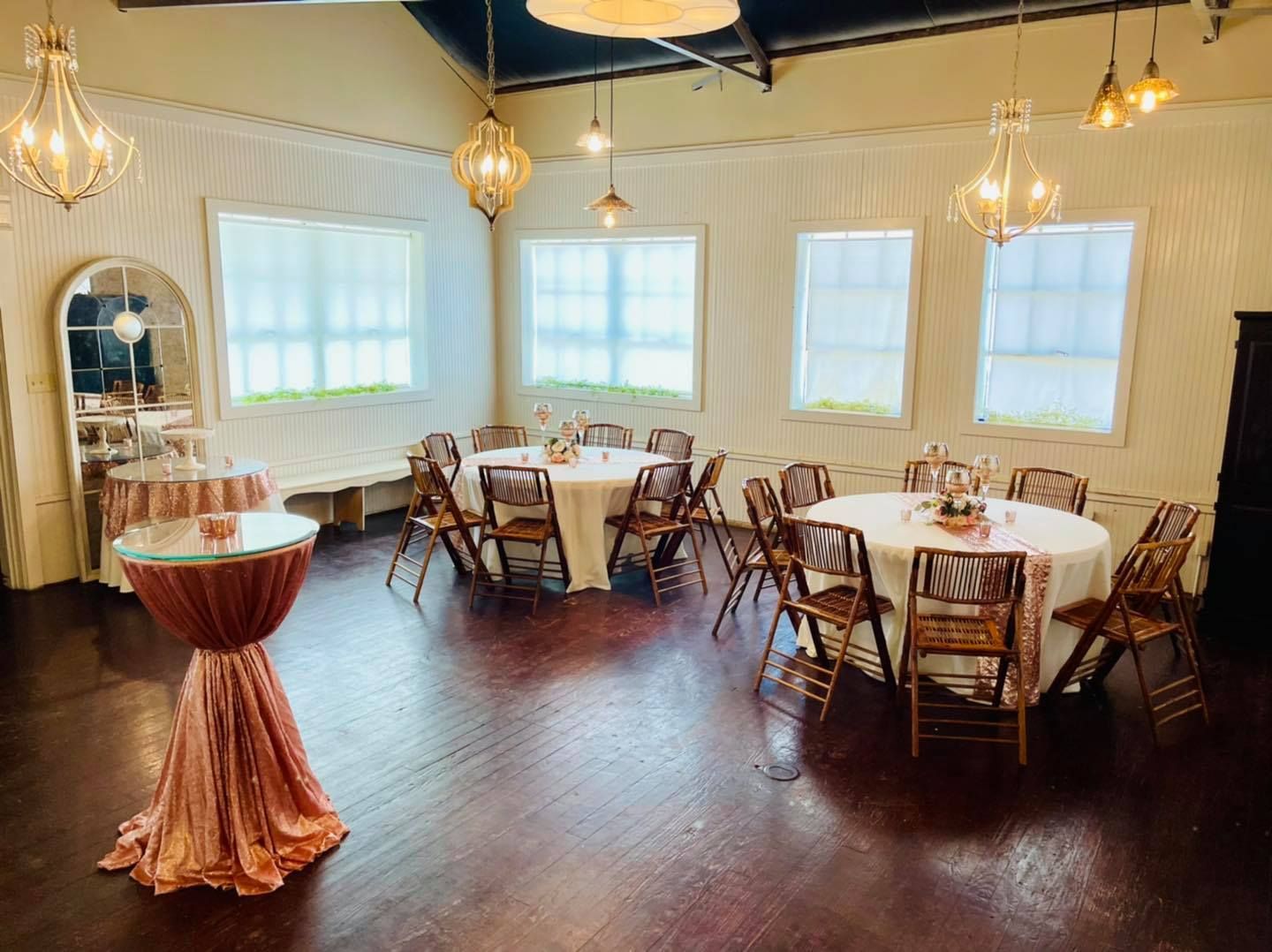 A room with tables and chairs set up for a wedding reception.