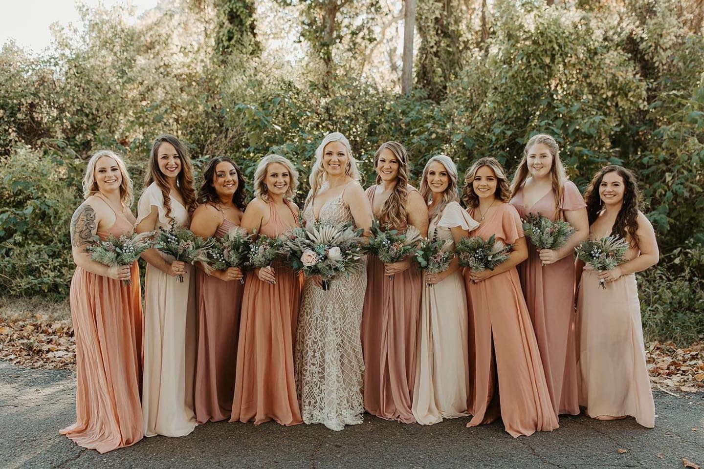 A bride and her bridesmaids are posing for a picture together.
