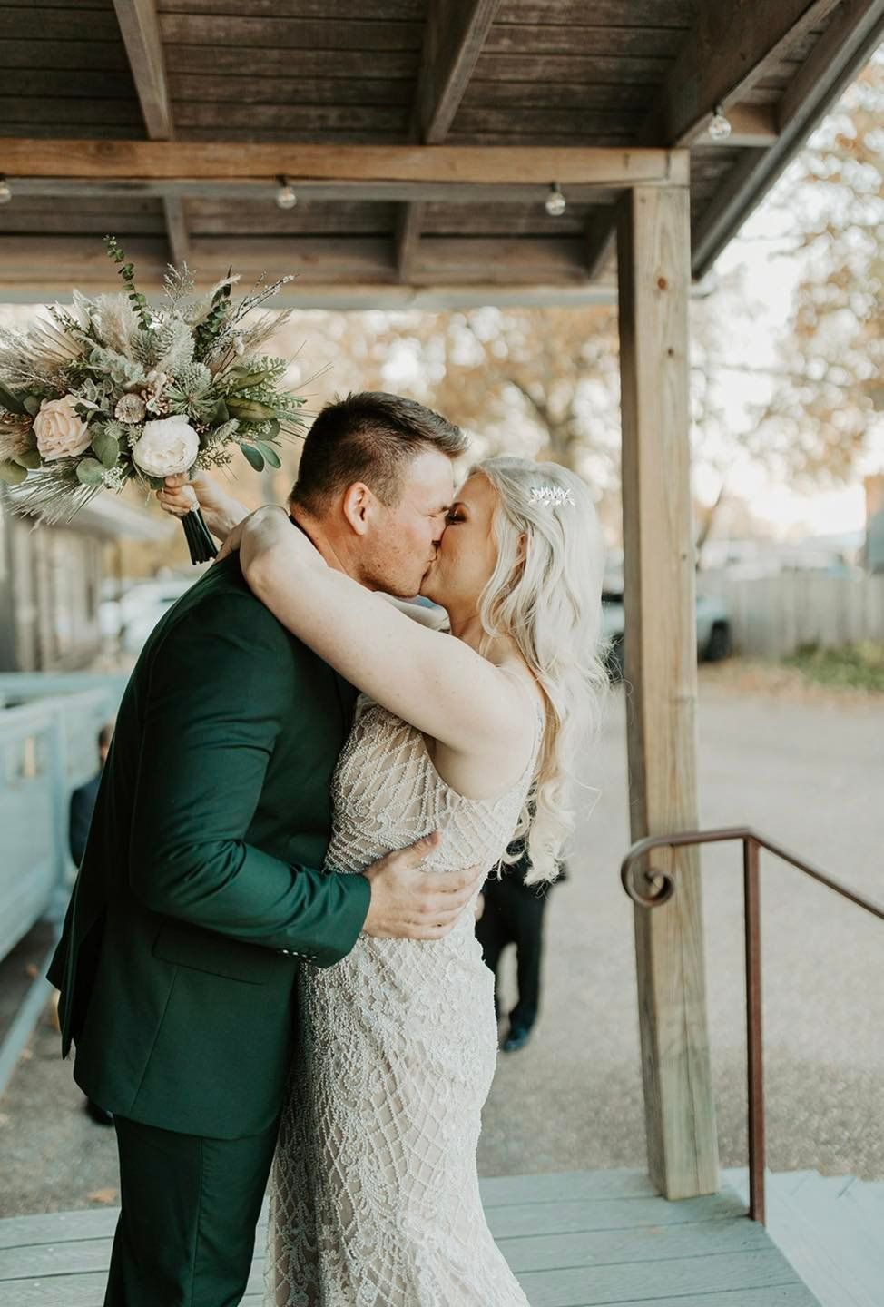 A bride and groom kissing under a canopy on their wedding day.