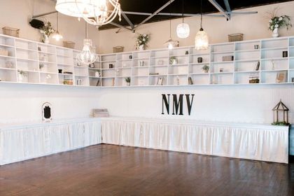 A large empty room with lots of shelves and a chandelier.