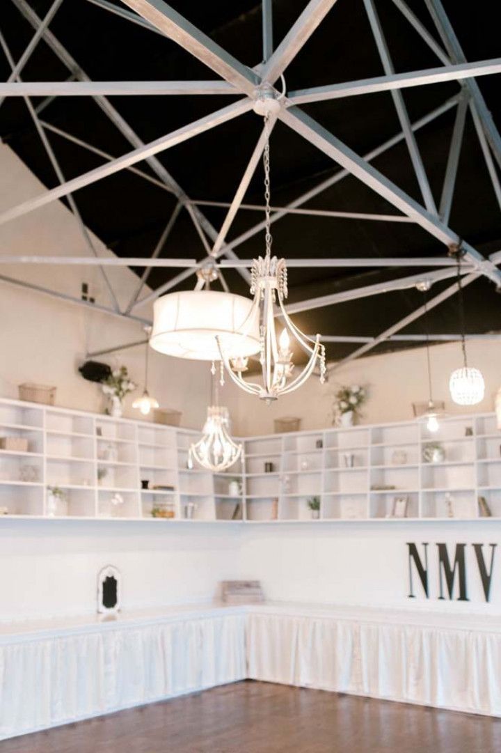 A large room with a lot of shelves and a chandelier hanging from the ceiling.