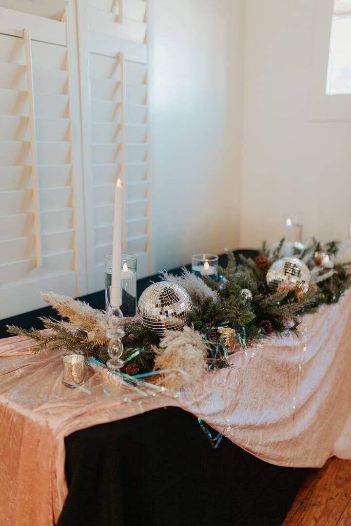 A long table with candles and flowers on it in a room.
