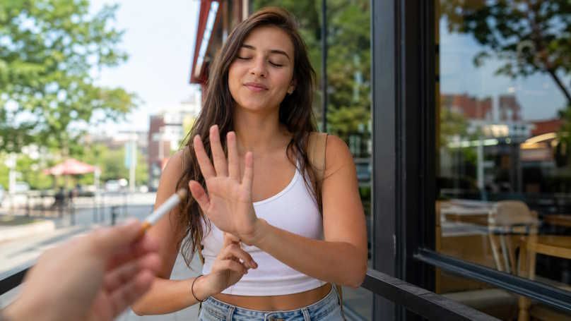woman in OKC turning away a cigarette she was offered from a friend as she tries to quit smoking