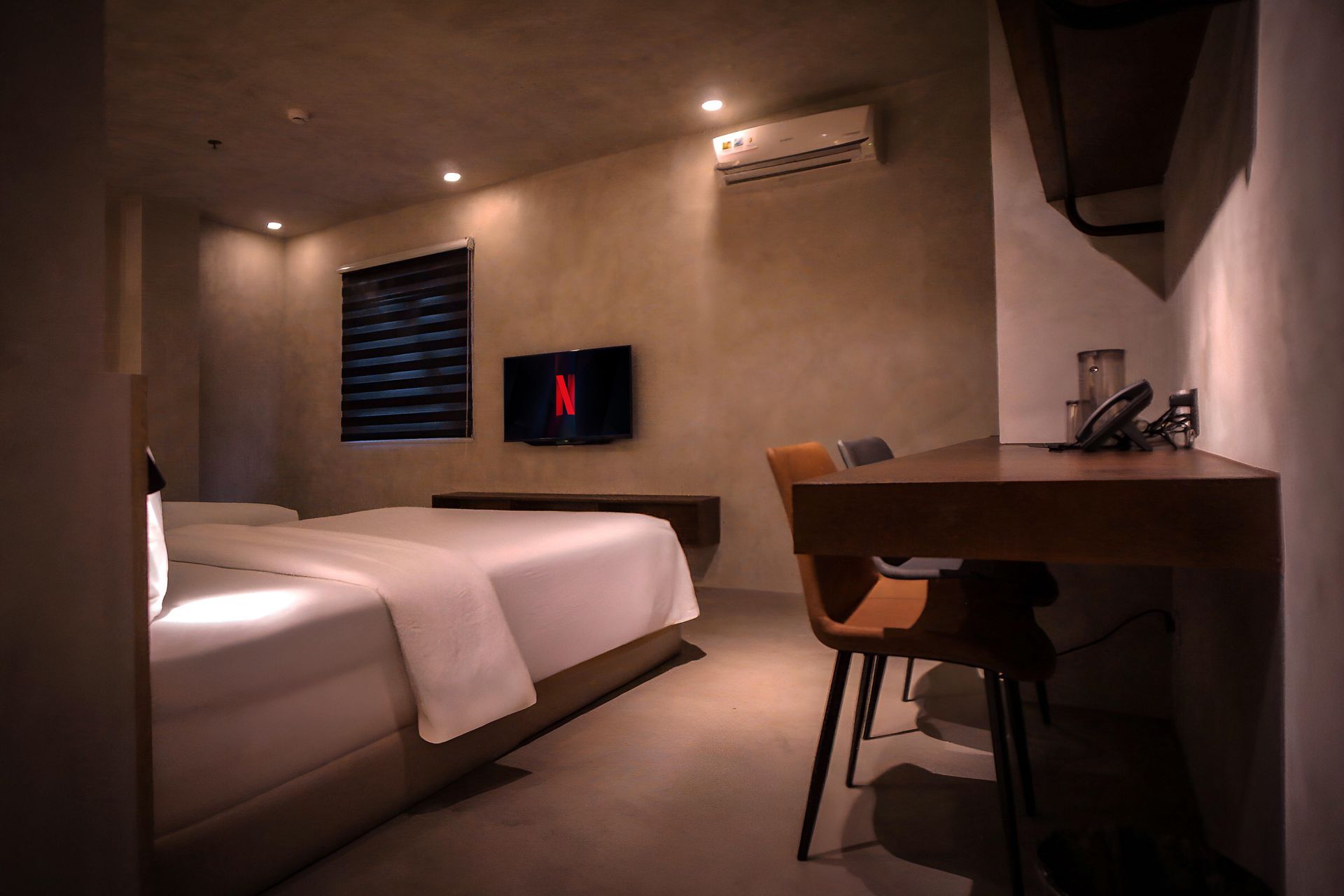 A hotel room with two beds , a desk and a television.