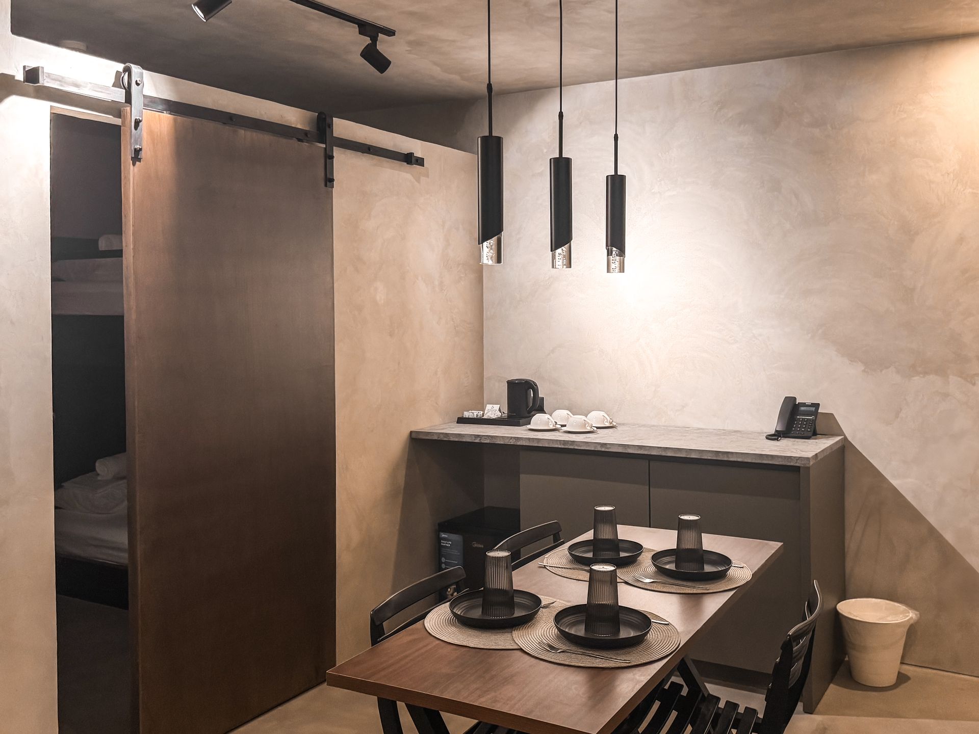 A dining room with a table and chairs and a sliding barn door.