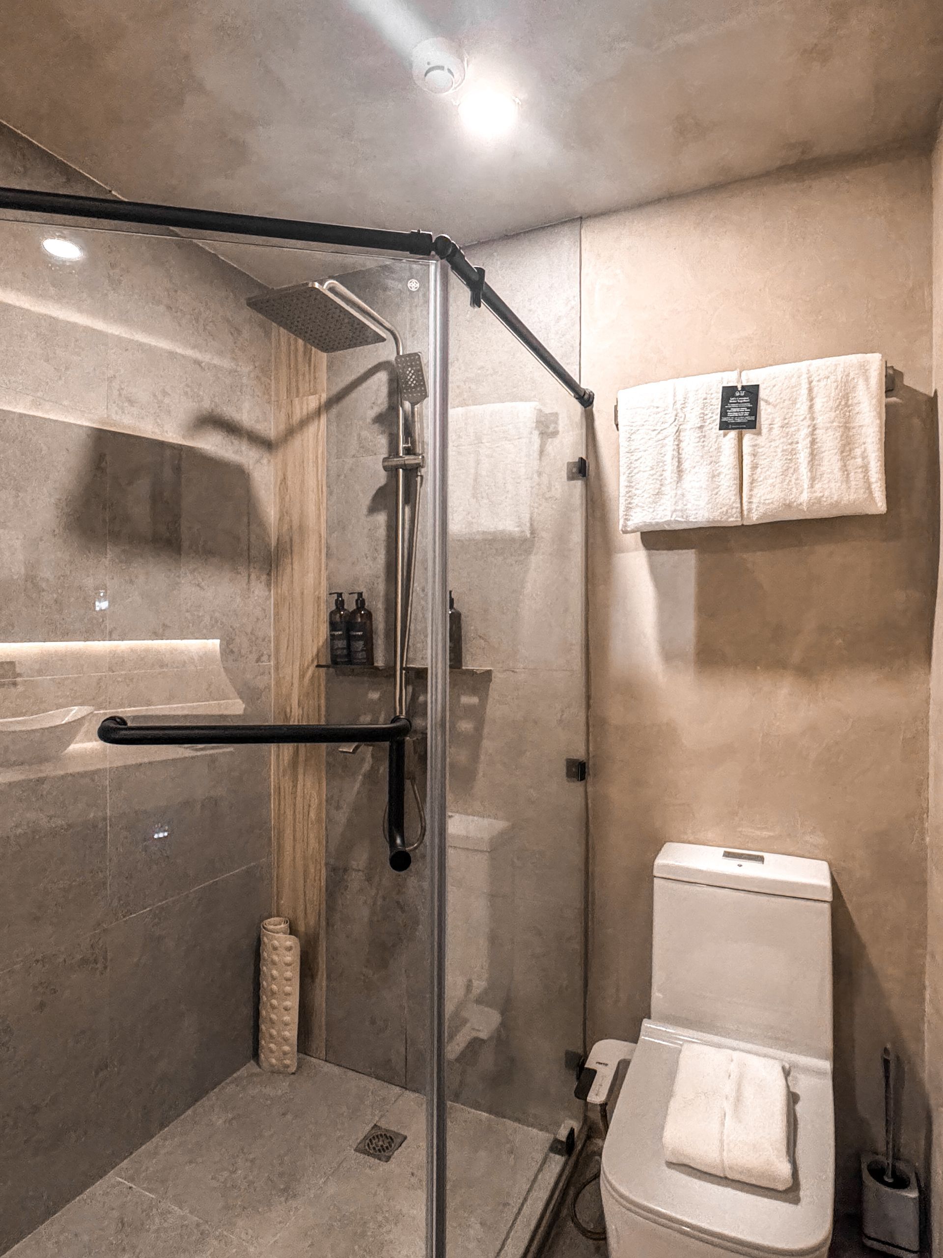 A bathroom with a toilet and a shower with a glass door.