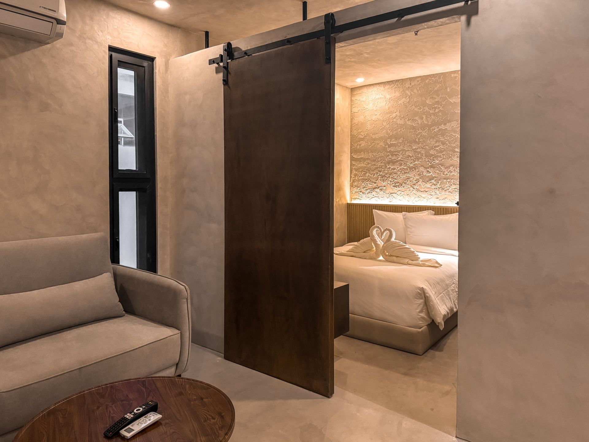 There is a sliding barn door between the living room and the bedroom.