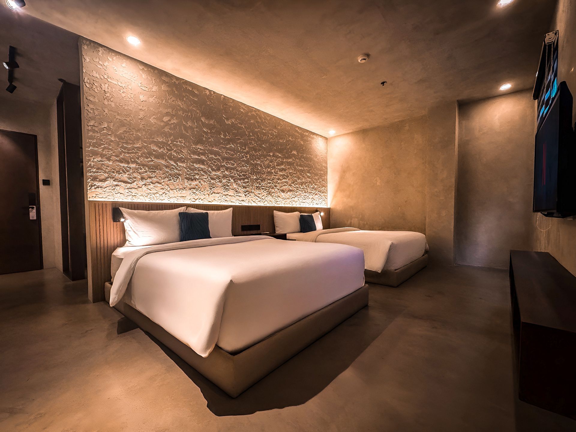 A hotel room with two beds and a television.