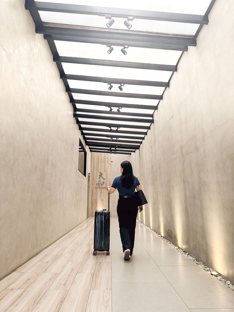 A large bonsai tree is sitting in front of a set of stairs.