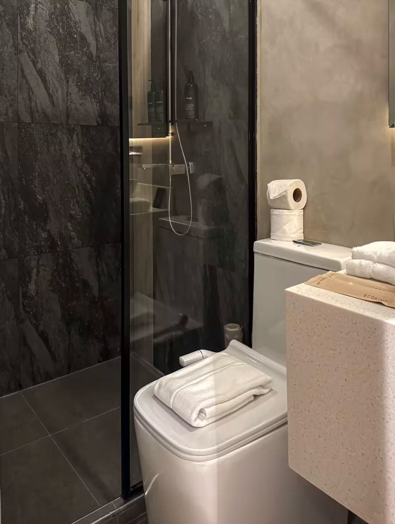 A bathroom with a toilet , sink , and shower.
