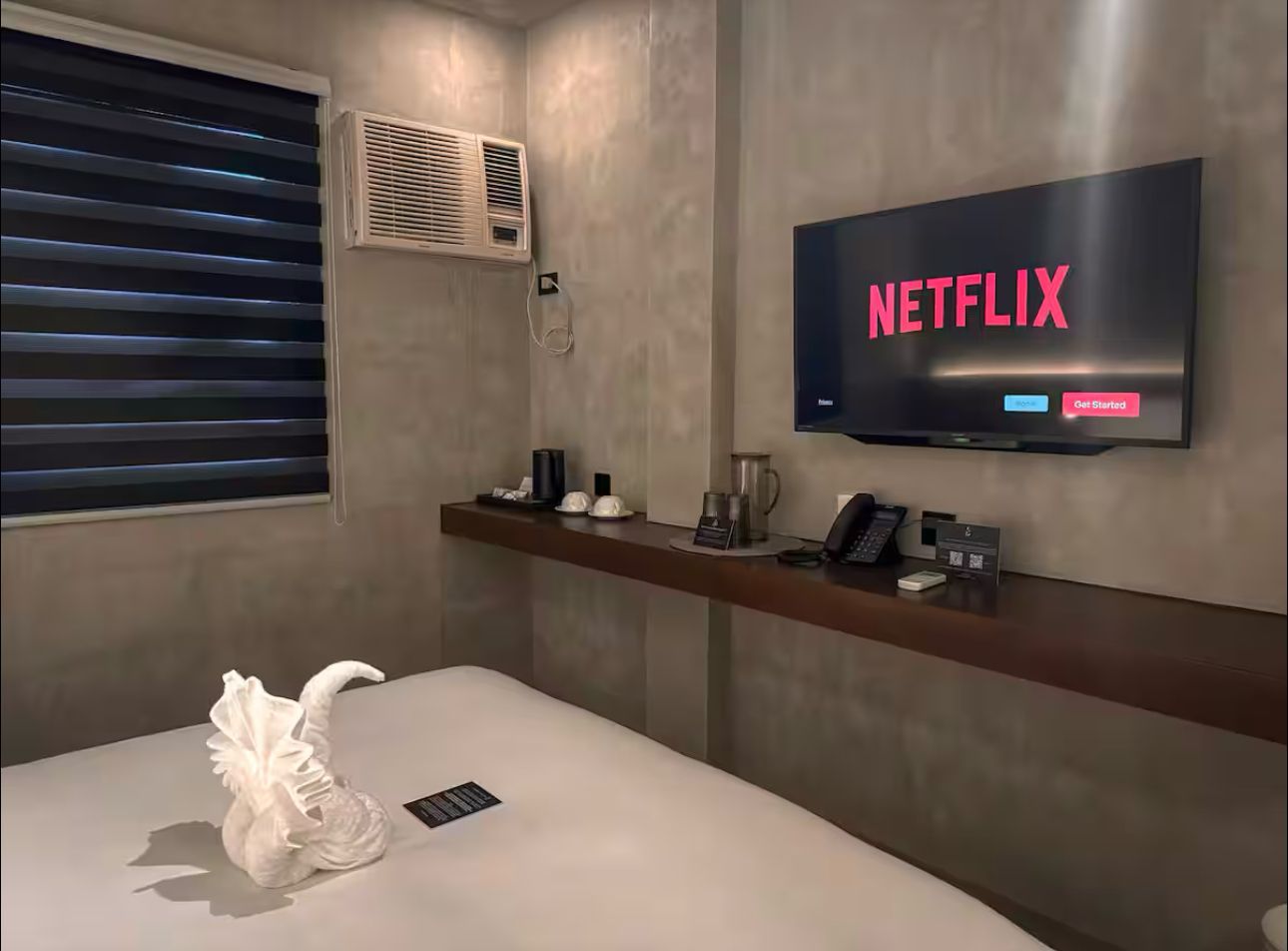 A hotel room with a bed and a flat screen tv.