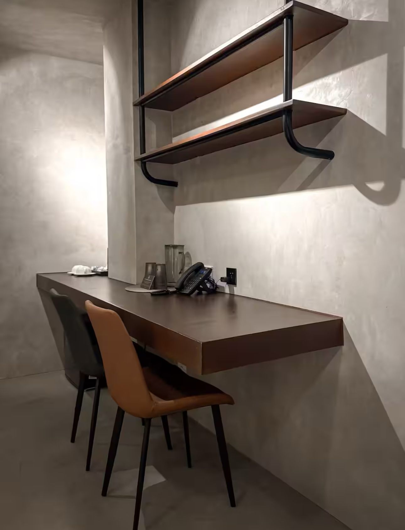 A desk with two chairs and a phone on it in a room.