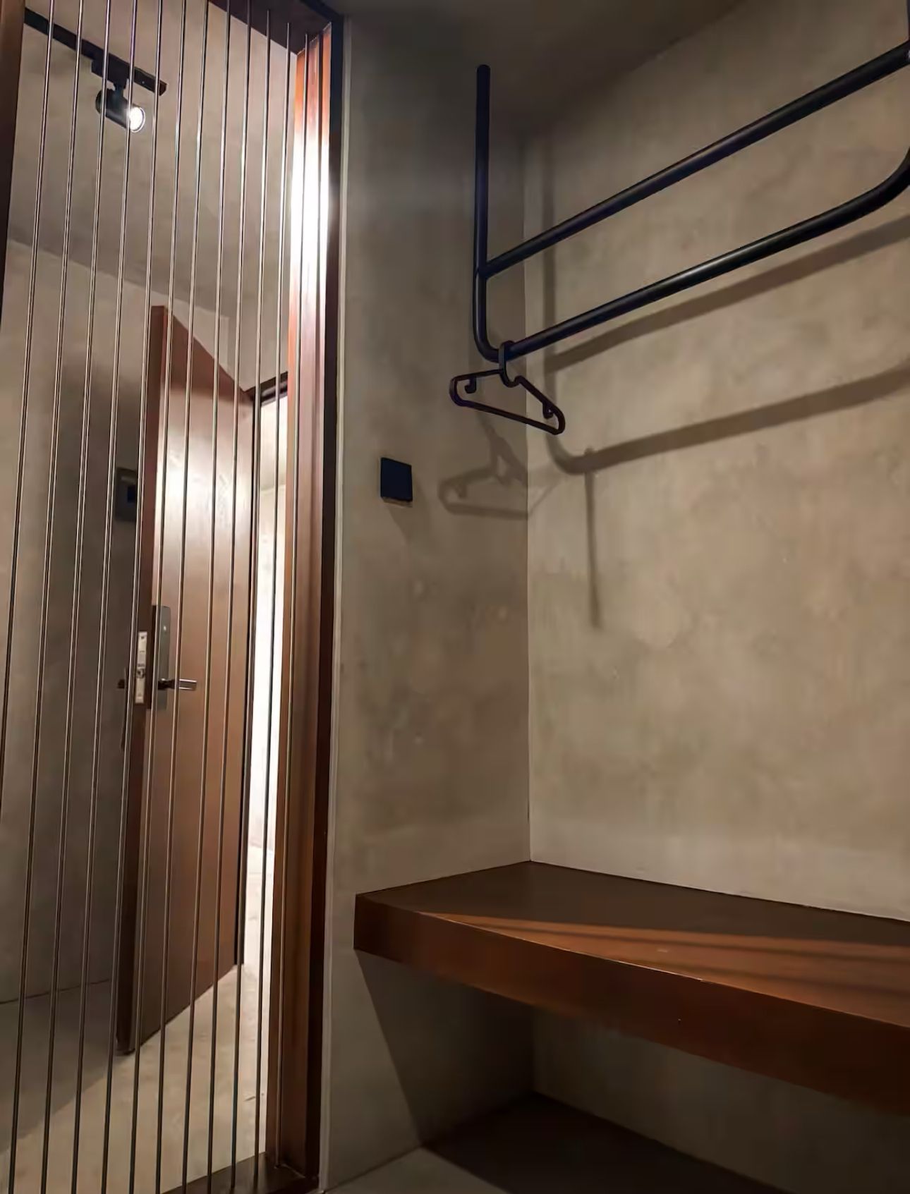 A closet with a wooden shelf and hanging clothes