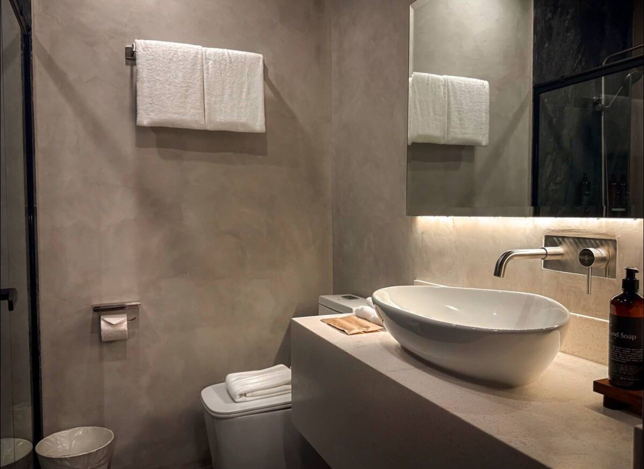 A bathroom with a sink , toilet and mirror.