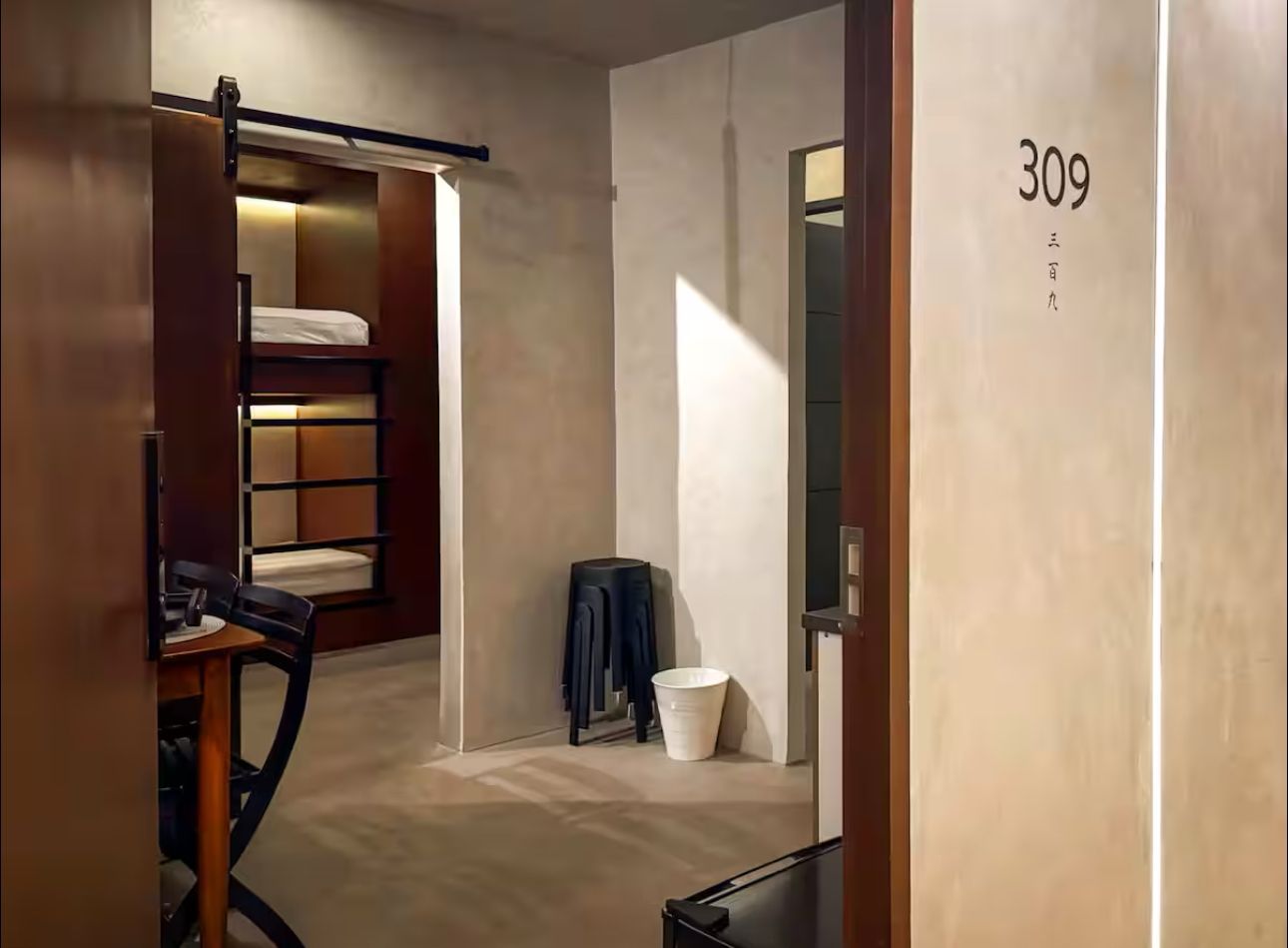 A hotel room with a sliding barn door and a bunk bed.