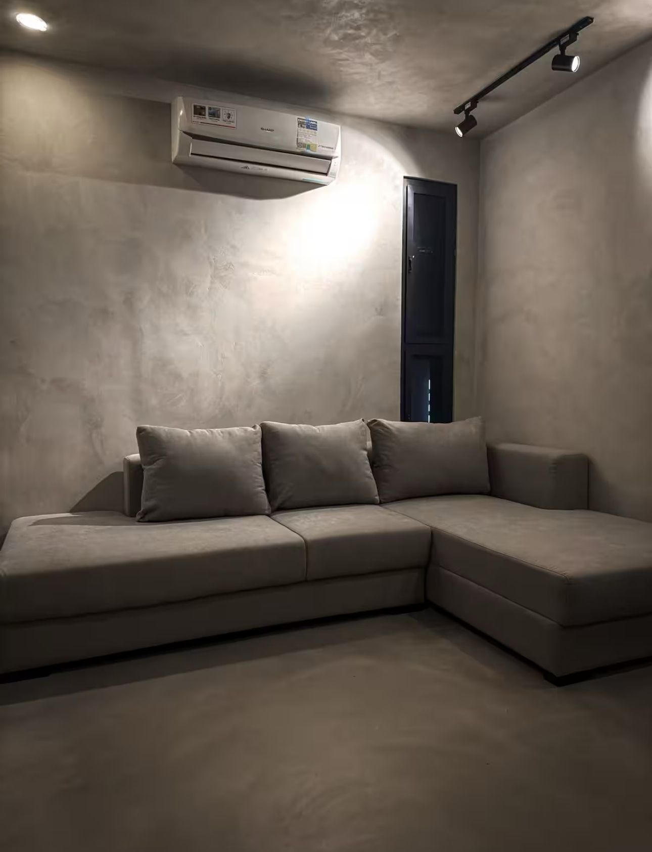 A living room with a sectional couch and a window.