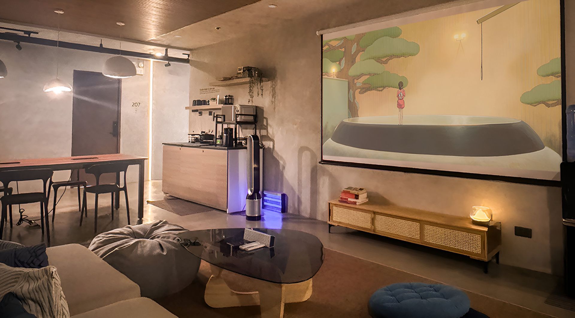 A living room with a large painting on the wall and a projector screen.