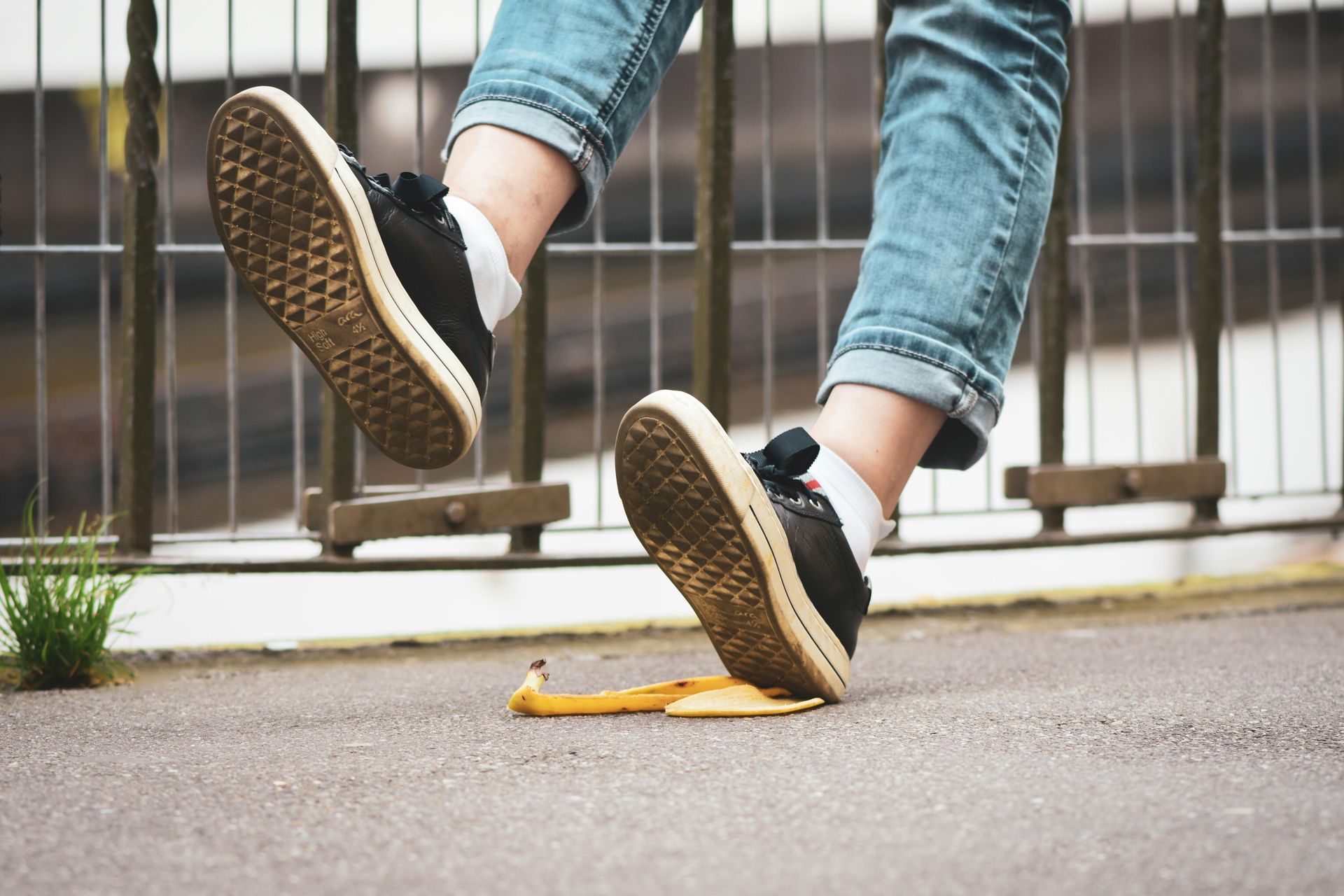 A person is slipping on a banana peel on the ground.