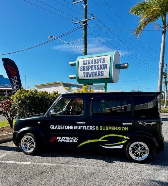 Black Car With Shop Sign — Gladstone Mufflers & Suspension In Gladstone Central, QLD