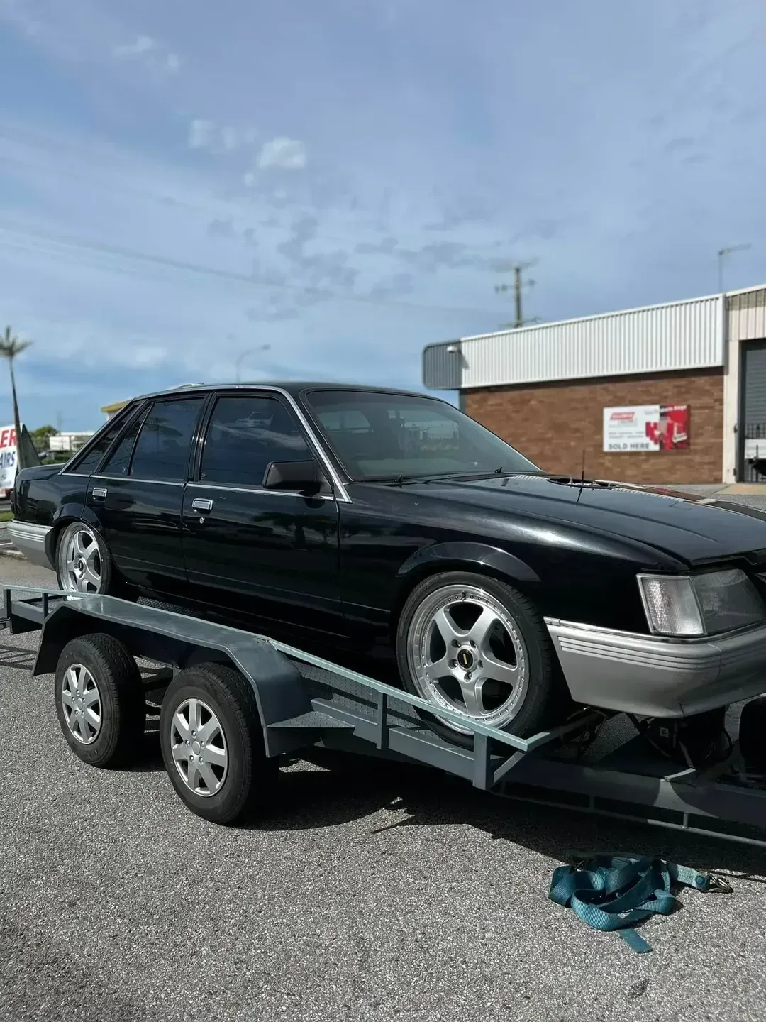 Black Sedan Car on a Trailer — Gladstone Mufflers & Suspension In Gladstone Central, QLD