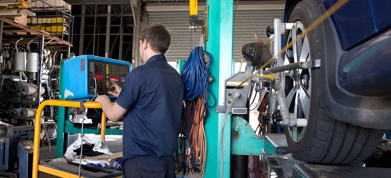 Mechanic Adjusting Tire Alignment — Gladstone Mufflers & Suspension In Gladstone Central, QLD
