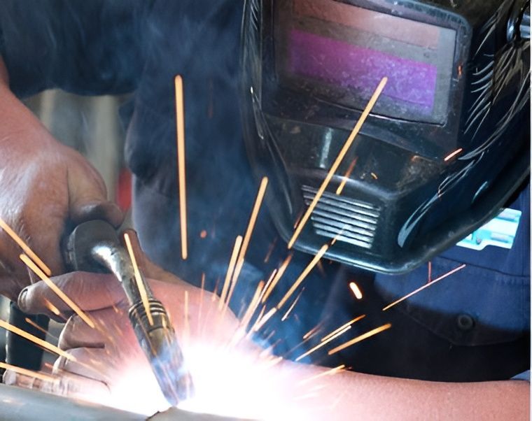 Welder in Dark Helmet Welding Metal — Gladstone Mufflers & Suspension In Gladstone Central, QLD