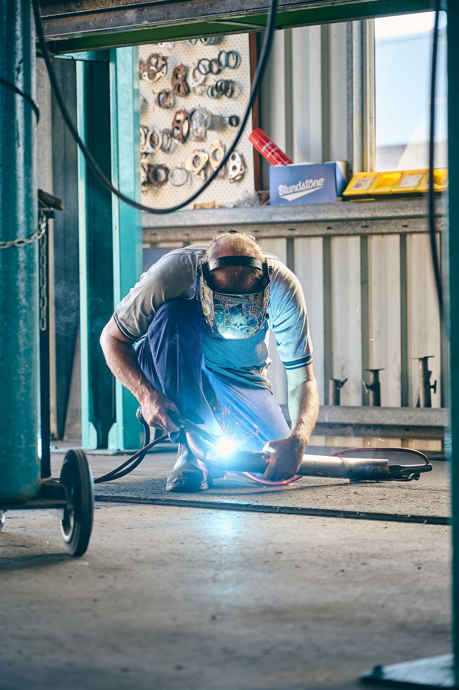 Welder in Protective Gear Welding Metal — Gladstone Mufflers & Suspension In Gladstone Central, QLD