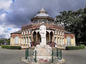 A statue of a man in a helmet is in front of a building.