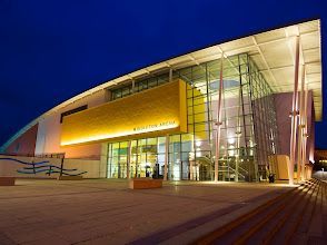 A large building with a lot of windows is lit up at night.