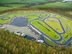 An aerial view of a race track surrounded by trees and grass.