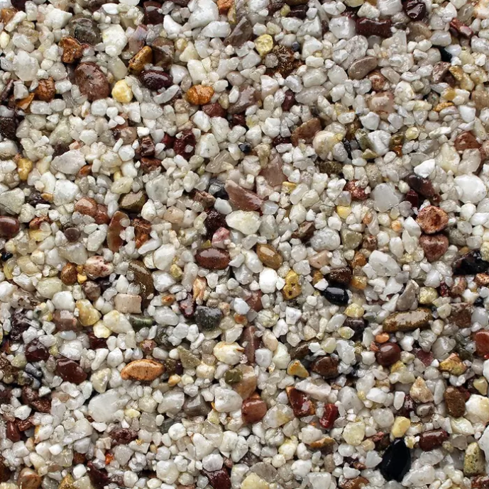 Close-up of a speckled, textured surface of small, rounded, mixed-color pebbles.