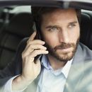 man talking on a phone in a car
