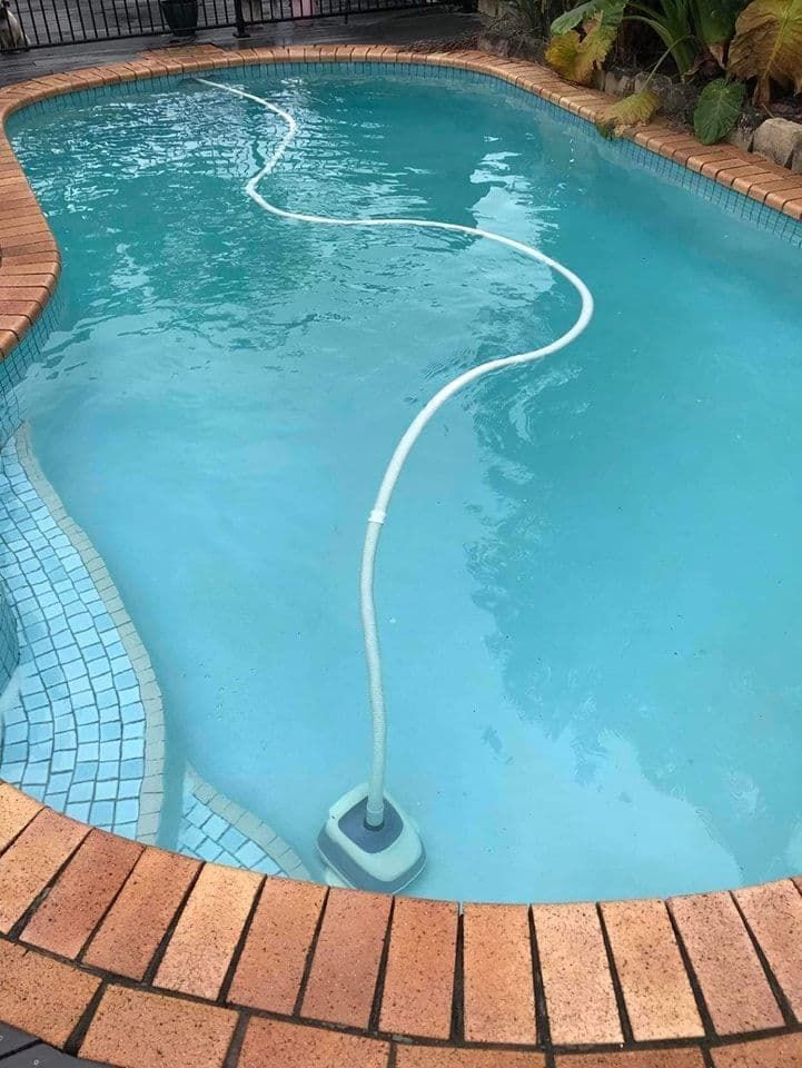 A Swimming Pool With a Hose Attached to It — Penguin Pools In Robina, QLD