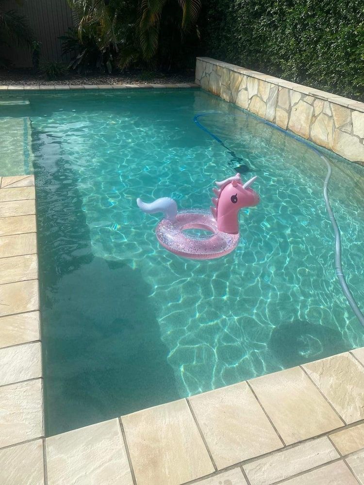 A Pink Unicorn Float is Floating in a Swimming Pool — Penguin Pools In Robina, QLD