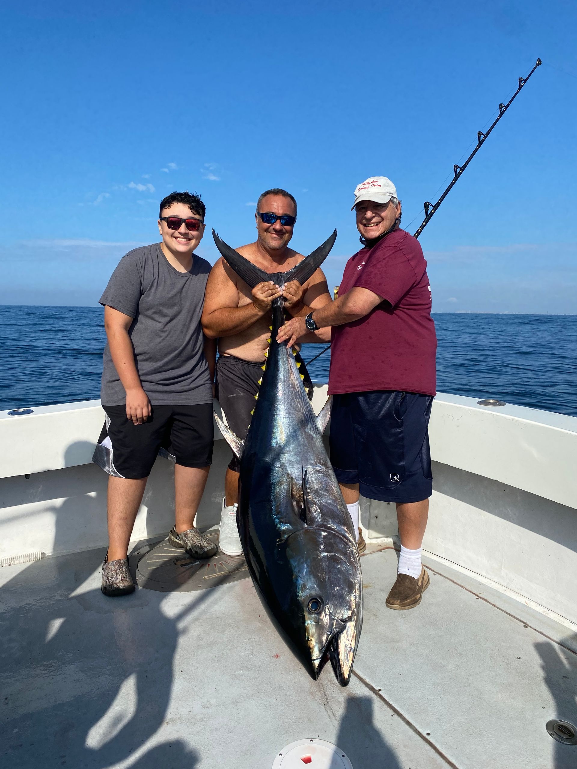 three guy holding their catch tuna