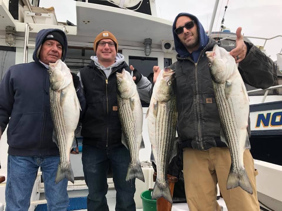 three men holding big fish