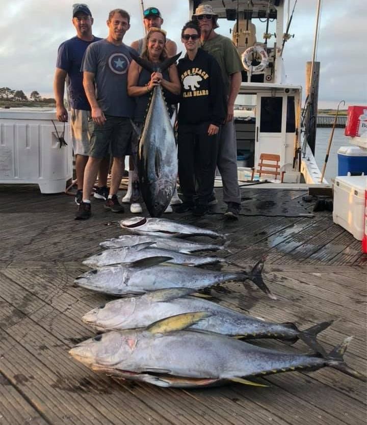 group of people carrying big fish