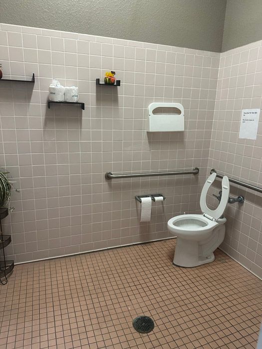 A bathroom with a toilet and a sign on the wall