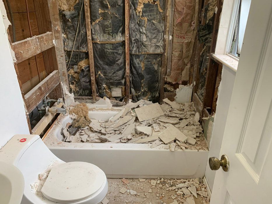 A bathroom with a toilet , sink and bathtub being remodeled.
