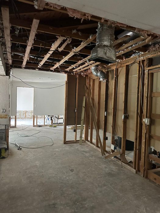 A room under construction with wooden beams and a ladder.