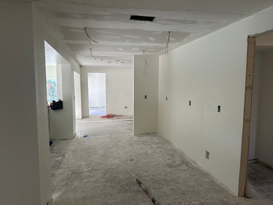 A large empty room with white walls and a carpeted floor.