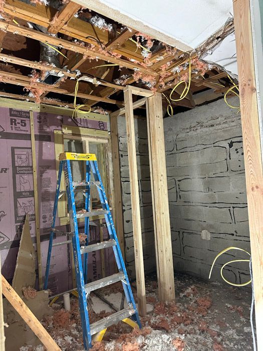 A ladder is sitting in the middle of a room under construction.