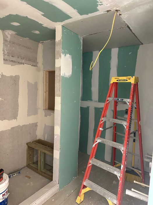 A ladder is in a room that is being remodeled