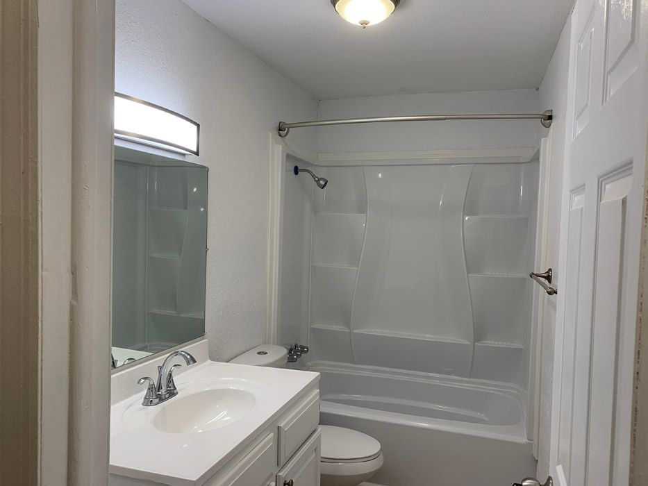 A bathroom with a sink , toilet and bathtub.