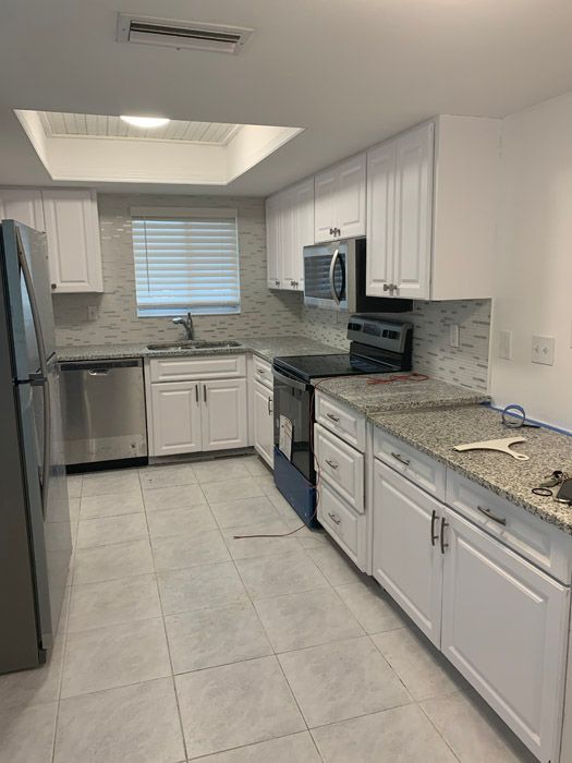 A kitchen with white cabinets and stainless steel appliances.